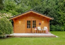 Wooden garden shed with two chairs outside. Wooden house with a